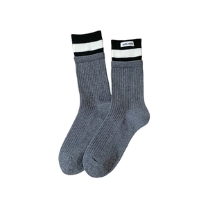 Dark grey ribbed mid-calf socks with black and white striped cuffs and woven label