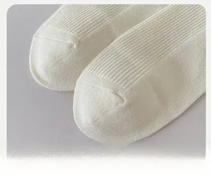 Detailed macro view of the reinforced toe design on white ribbed knit cotton socks