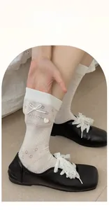 Macro shot of high elasticity white crew sock featuring ribbon bows and heart charms
