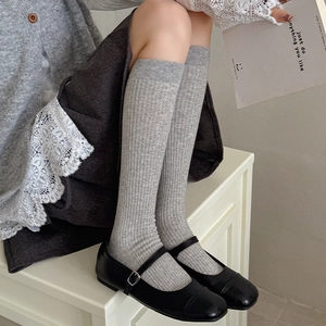 Grey ribbed calf-length socks styled with black Mary Jane shoes and a lace-trimmed skirt