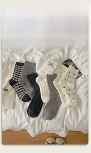 Detail showing various cotton mid-calf socks with plaid patterns and bow decorations