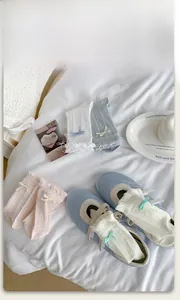 Detail of sweet cotton mesh socks with ruffled lace edges and cute ribbon bows