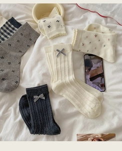 Flat lay of Korean style socks with bows, floral prints, and plaid knit patterns