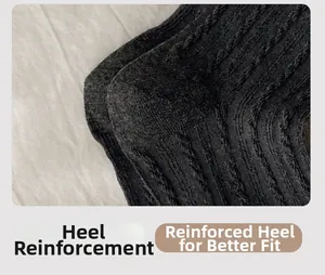 Macro shot of reinforced heel on black knit socks showing durable rib texture detail