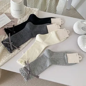 Women's ribbon bow mid-calf socks in four neutral colors with chic button accents