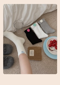 Close-up of knit crew socks with ribbed texture and colorful crochet heart details