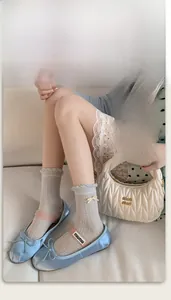 Detailed view of light gray mesh socks featuring lace edges and small yellow bows