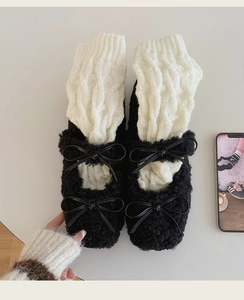 Détail de jambières en maille torsadée avec chaussures Mary Jane à nœuds noirs