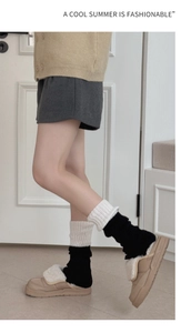 Détail de jambières en tricot bicolore avec des chaussons à plateforme en peluche