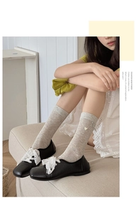 Detail of sweet bow socks with mesh heart pattern and elegant white lace laces