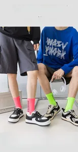 Detail of neon green and pink crew athletic socks with geometric checkered pattern