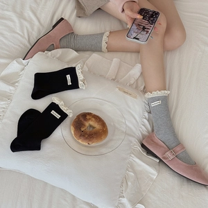 Lace trim crew socks in black and grey with letter patch shown with Mary Janes