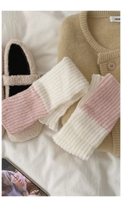 Gros plan de jambières en tricot bicolore rose et blanc avec texture côtelée verticale