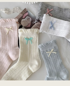 Detail of sweet cotton mesh socks featuring delicate bow accents and ruffled lace cuffs