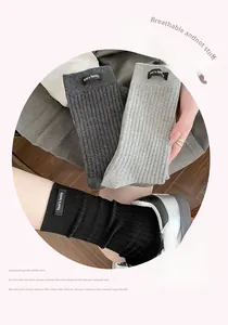 Close-up of ribbed knit cotton socks in grey and black with Tom's family woven label