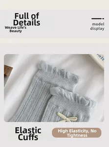 Detail of light blue mesh socks featuring frilly cuffs and a small beige bow ornament