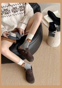 Detail of gray and beige patchwork socks with cute cartoon bear jacquard pattern