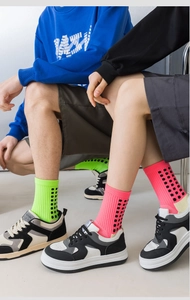 Detail of ribbed sports socks in neon green and rose pink with black square pattern