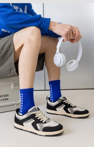 Detail of blue crew socks with white grid patterns paired with casual sports sneakers