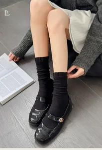 Detail of black ruffled lace socks with ribbed texture paired with Mary Jane shoes