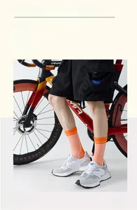 Detail of orange cycling socks with sports shoes and high-end road bike in studio set