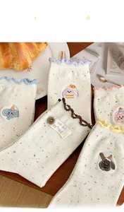 Detailed view of embroidery and colorful ruffled edges on soft cotton crew socks