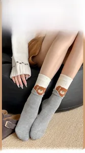 Detail of gray cartoon bear socks with a two-tone patchwork design and cozy fabric texture