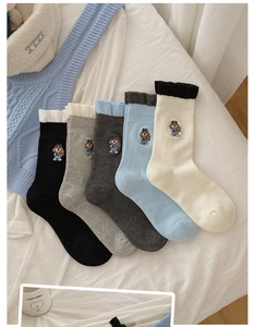 Détail de chaussettes en coton en cinq couleurs avec broderie de chien et bords côtelés