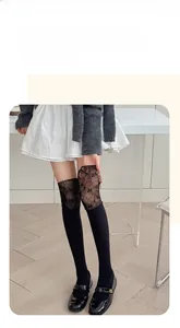 Détail de chaussettes hautes noires avec dentelle florale et texture en maille côtelée