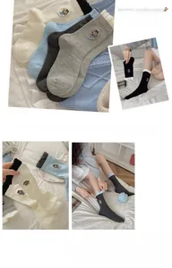 Détail de chaussettes en coton avec bords ondulés et broderie chiot mignon en couleurs