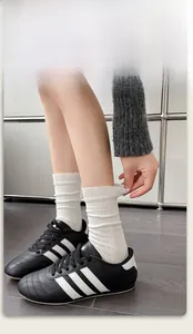 Detail of white ribbed cotton socks featuring high elastic cuffs and vertical knit texture