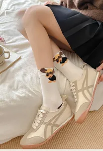 Detail of white cotton crew socks featuring cute cartoon puppy graphics and soft knit texture