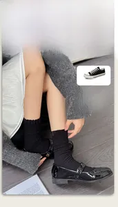 Close-up of black ribbed crew socks with ruffled edge paired with Mary Jane shoes