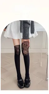 Détail de chaussettes hautes noires en dentelle patchwork avec bande élastique en Lycra