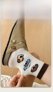 Detail view of high-elasticity cream crew socks featuring cute cartoon bear patterns