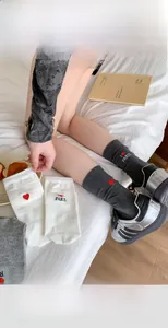 Detail of grey and white socks featuring I Love Paris heart embroidery on the ankle