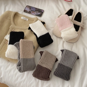 Jambières bicolores en tricot côtelé aux tons Morandi sur fond minimaliste