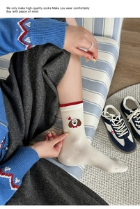 Vue détaillée de chaussettes mi-mollet en maille crème avec broderie de chiot mignon