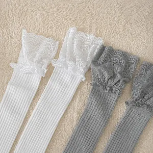Détail de la bordure en dentelle élastique sur des bas gris et blancs avec texture côtelée