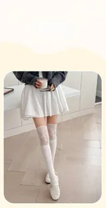 Détail de chaussettes montantes blanches avec bordure en dentelle et texture côtelée
