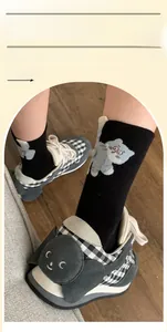 Detail of funny cat socks with black and white checkered sneakers and cat ear decor