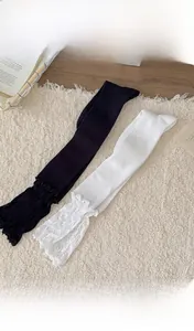 Détails de chaussettes hautes en maille côtelée avec bordure en dentelle blanche