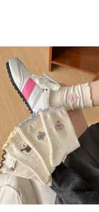Detail of cute animal embroidery and wavy ruffled cuffs on beige dot yarn crew socks