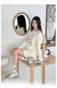 Close-up of beige cable knit sweater with bunny embroidery and matching skirt