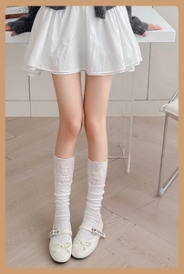 Detailed view of white ballet style lace socks paired with Mary Jane shoes and a bow