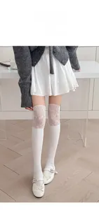 Détail de la dentelle blanche et du motif en tricot côtelé sur des chaussettes montantes