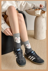 Detail view of gray crew socks featuring cute cartoon rabbit embroidery and a ribbed cuff