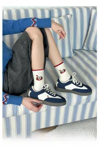 Détail de chaussettes en coton avec broderie chiot mignon et baskets rétro bleues