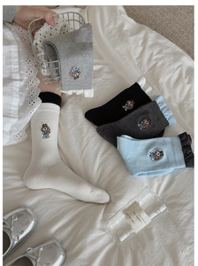 Détail de broderie chien mignon et bordure à volants sur chaussettes mi-mollet en coton