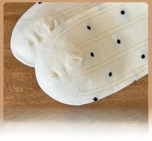 Macro della punta rinforzata su calze a coste color crema con motivi a pois neri